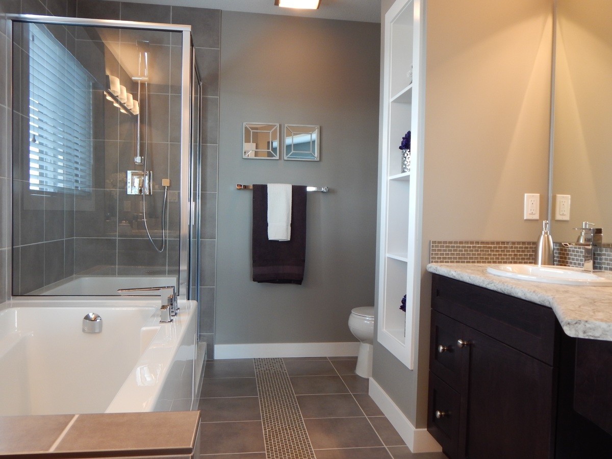 Image of bathroom with tiled-in rug, also showing towels on heated towel rack
